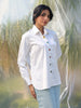 Woman wearing a white shirt with colorful stone buttons in a natural setting