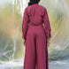 Person wearing a maroon coord set standing against a textured white background