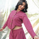 Woman wearing a pink outfit with heart-shaped buttons against a white background