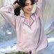 Woman in a light pink purple summery shirt with a blurred natural background