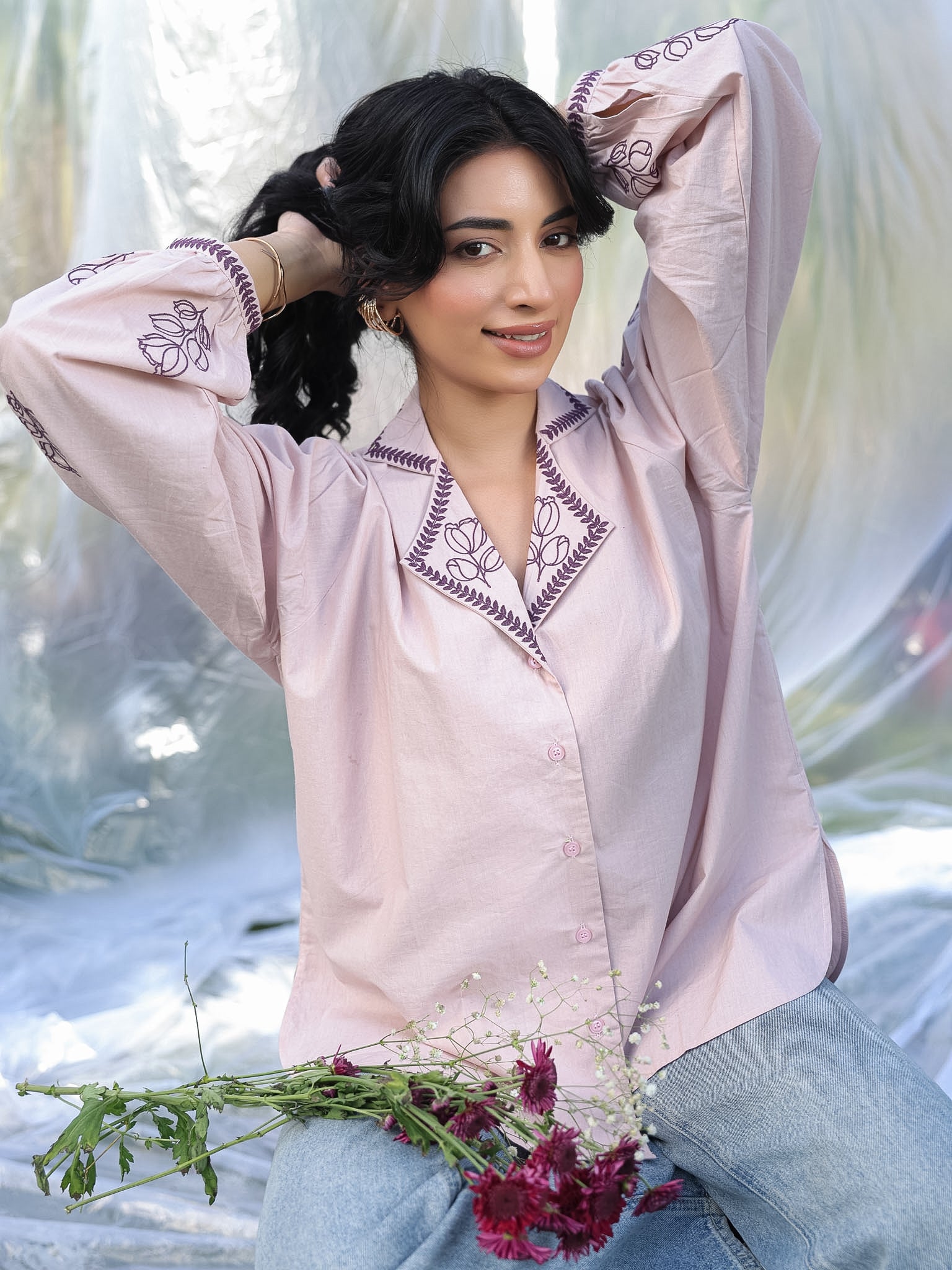 Woman in a light pink purple summery shirt with a blurred natural background