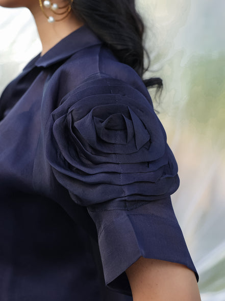 Navy blue shirt with a floral sleeve detail on a blurred background