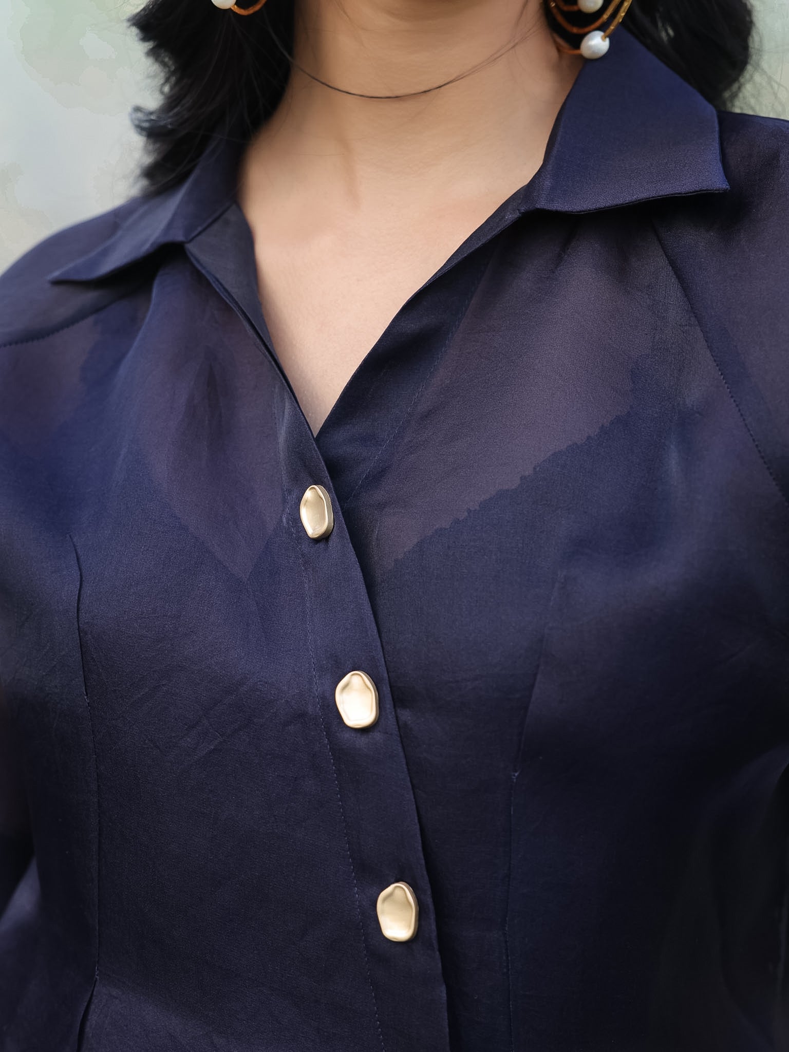 Navy blue shirt with gold buttons worn by a person