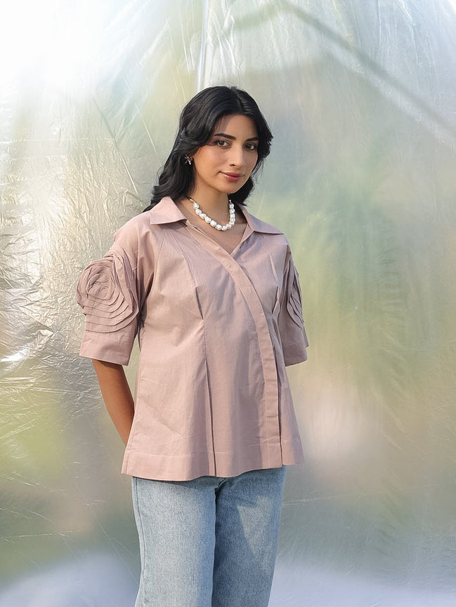 Woman in a brown shirt and light blue jeans standing amidst plastic wrap
