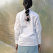 Person wearing a white shirt and light blue skirt standing in front of a large plastic sheet.