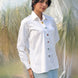 Woman wearing a white shirt with colorful stone buttons in a natural setting