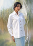 Woman wearing a white shirt with colorful stone buttons in a natural setting