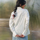 woman facing backwards wearing a stylish white shirt with smart pin tucks detailing in the back