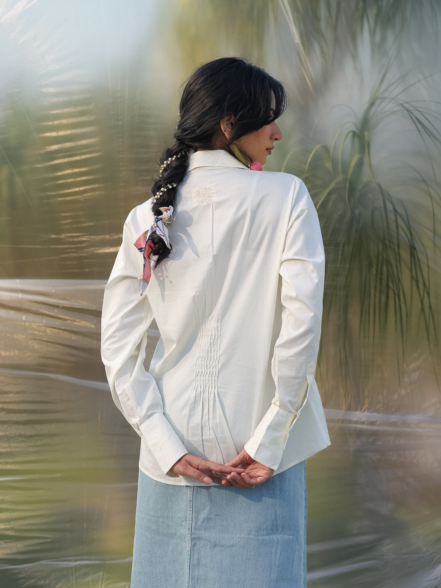 woman facing backwards wearing a stylish white shirt with smart pin tucks detailing in the back