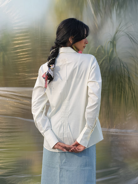 woman facing backwards wearing a stylish white shirt with smart pin tucks detailing in the back