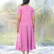 Person wearing a pink outfit with a blurred natural background
