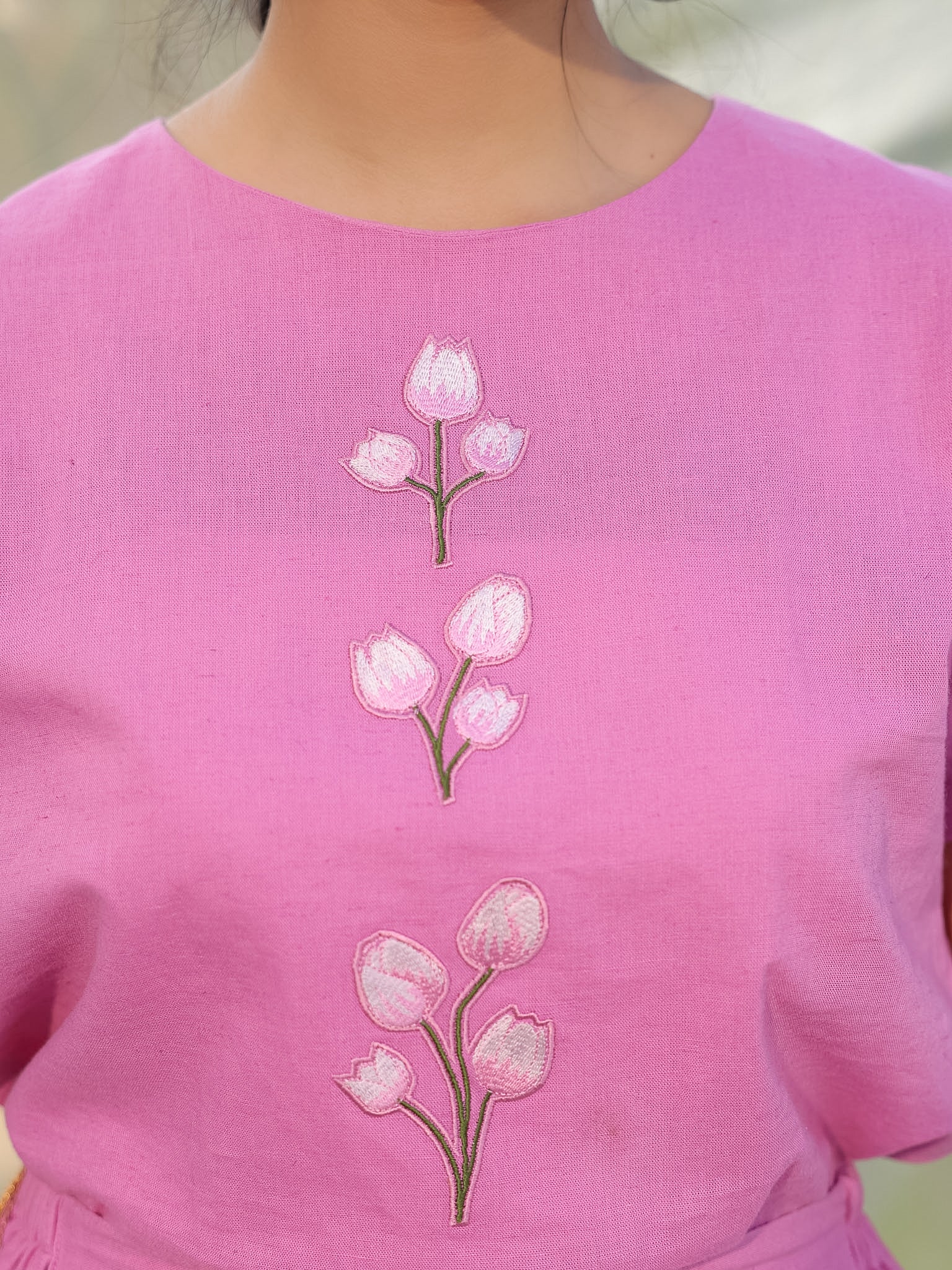 closeup of pink top with tulip embroidery which is appliqued