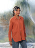 Woman wearing an orange shirt with a blurred natural background