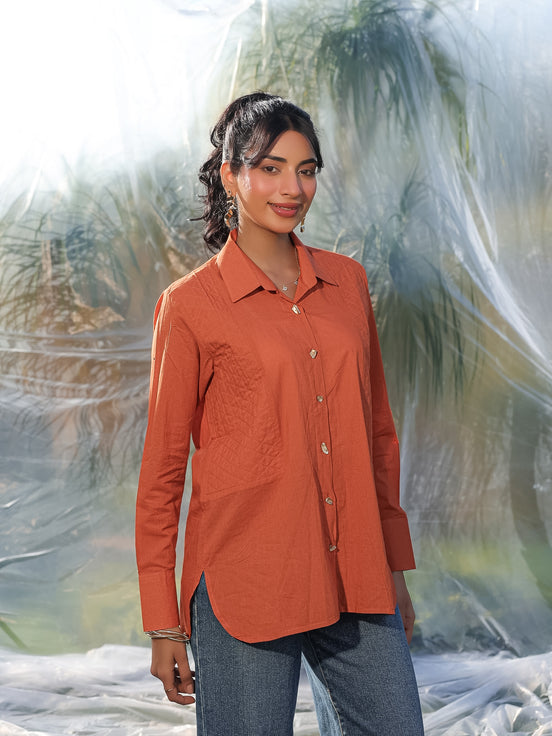Woman wearing an orange shirt with a blurred natural background