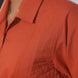 Close-up of a person wearing an orange quilted shirt