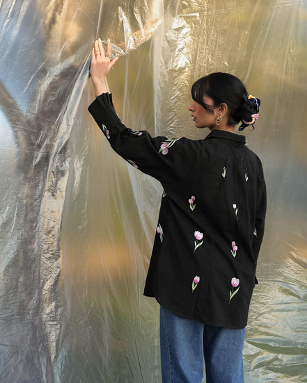woman wearing black jacket with delicate and stylish tulips embroidery all over the shirt with connector lace