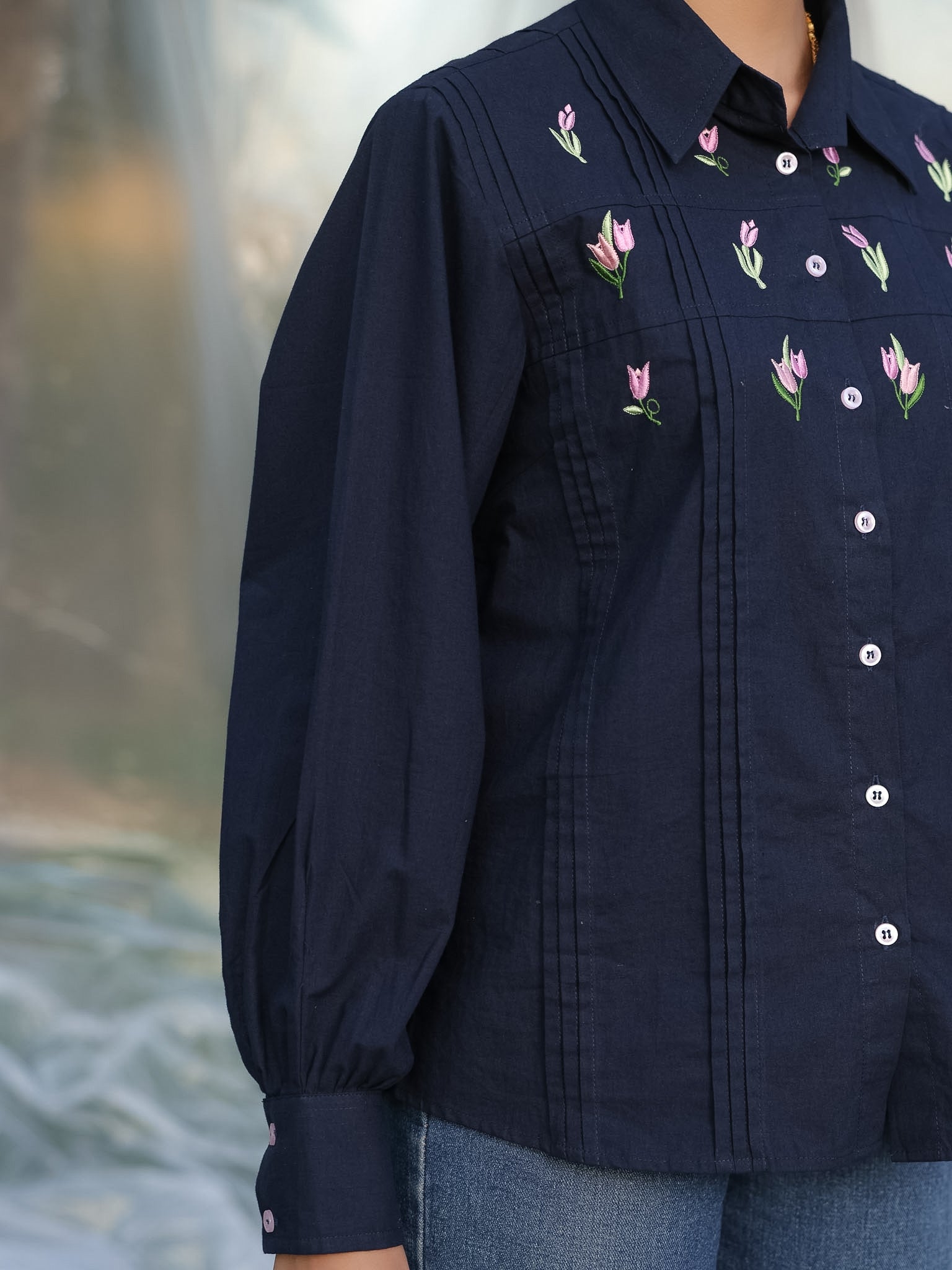 aesthetic shot of a woman wearing navy blue cotton shirt with beautiful and elegant floral embroidery with pintucks